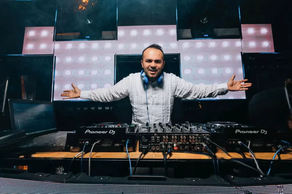 Award-winning wedding DJ in Colombia performing at a destination wedding in Cartagena, using Pioneer Nexus 2000 and DJM-900 mixer on a professional stage