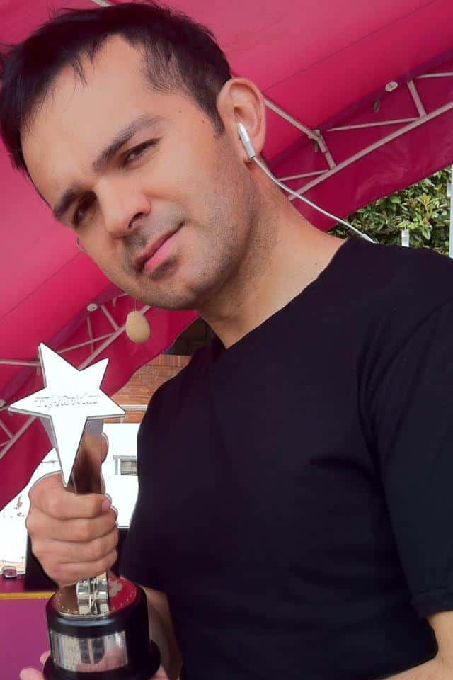 DJ Diego Sánchez sosteniendo premio como mejor DJ para bodas en Colombia en evento nacional